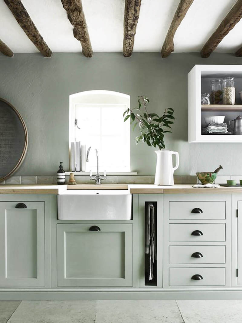 White farmhouse sink with muted green cabinets via Neptune