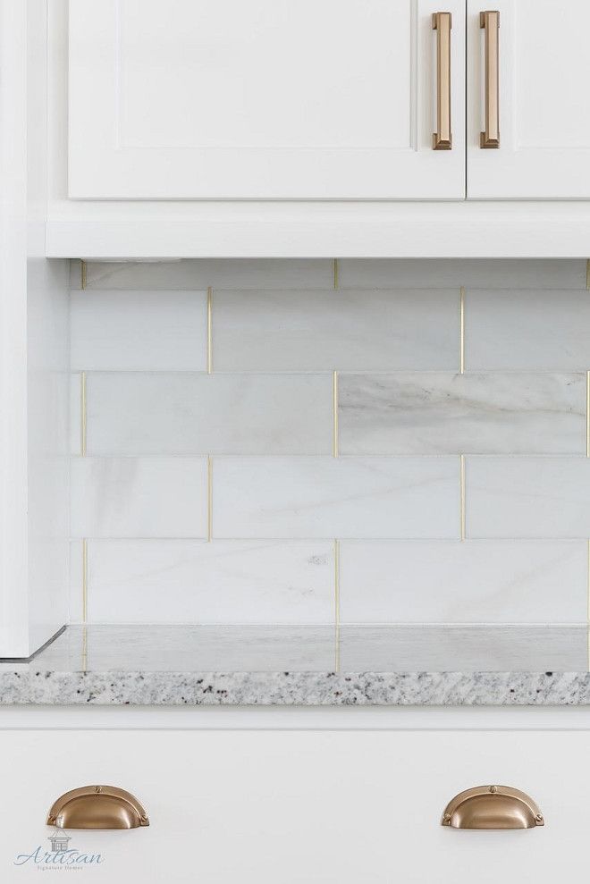 White marble kitchen backsplash with marble tiles brass grout via Artisan Signature Homes