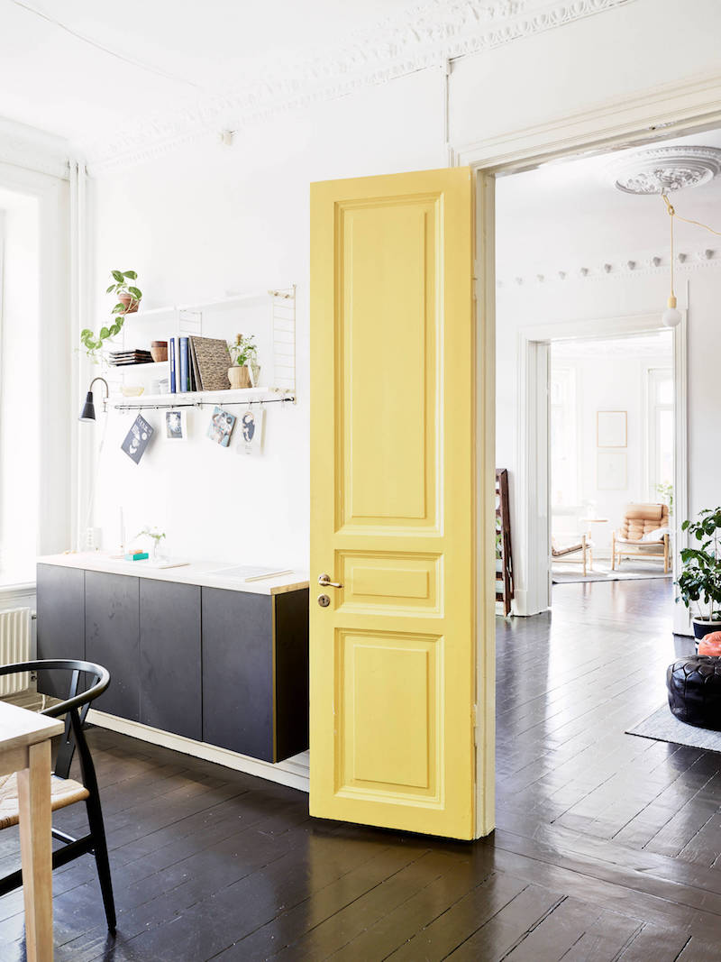 Swedish home with yellow interior door via Stadshem