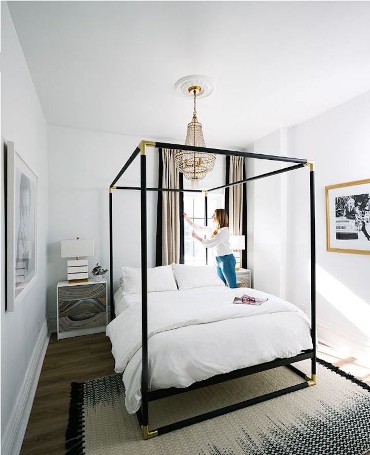 Black Canopy Bed by CB2 with French crystal chandelier via MyDomaine