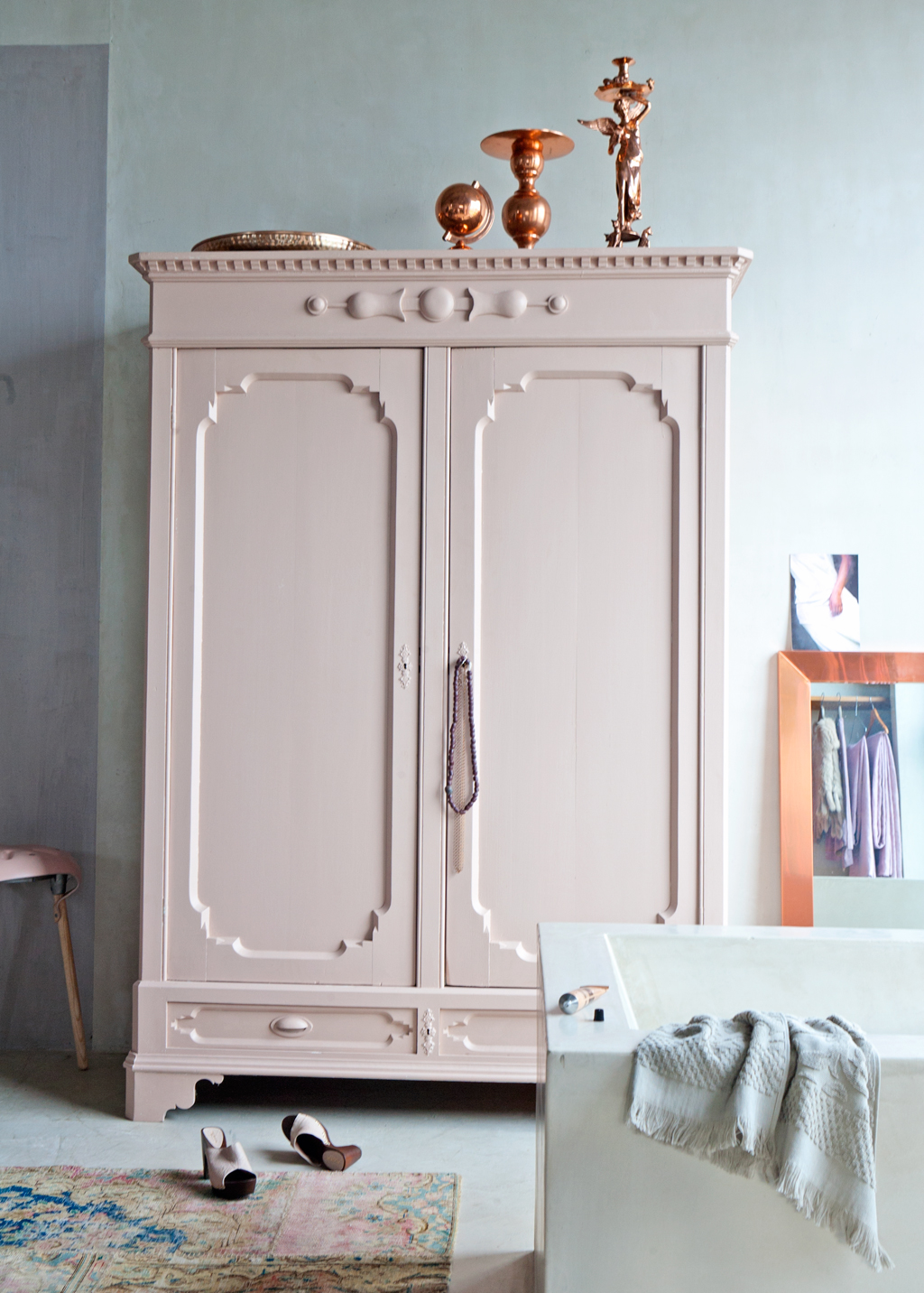 Soft pink armoire with copper decor accents