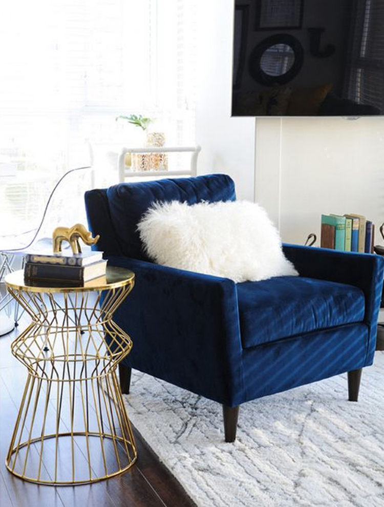 Blue velvet tufted accent chair with white throw pillow