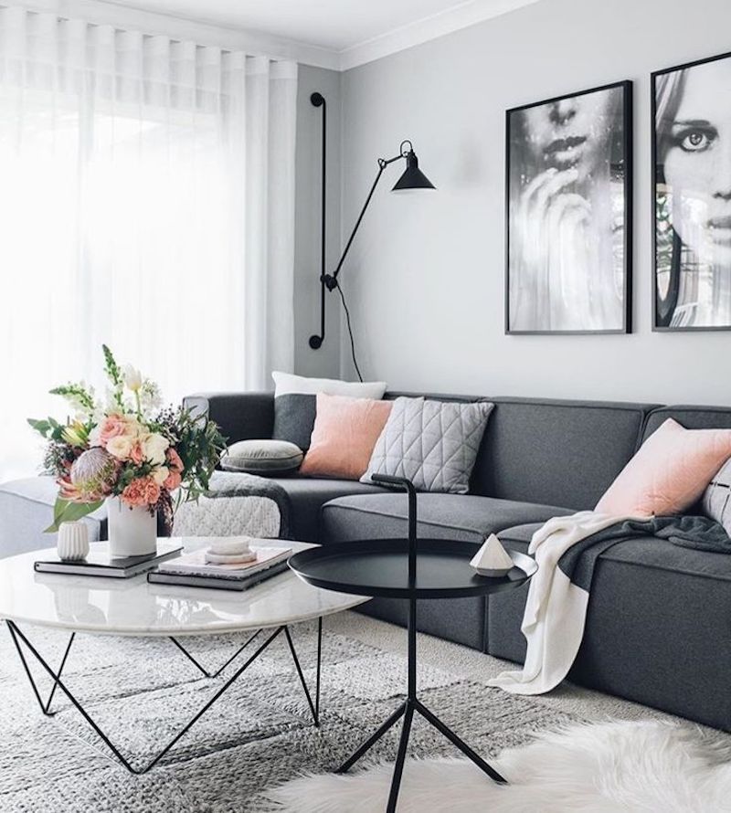 Dark grey sofa with marble coffee table and dramatic art