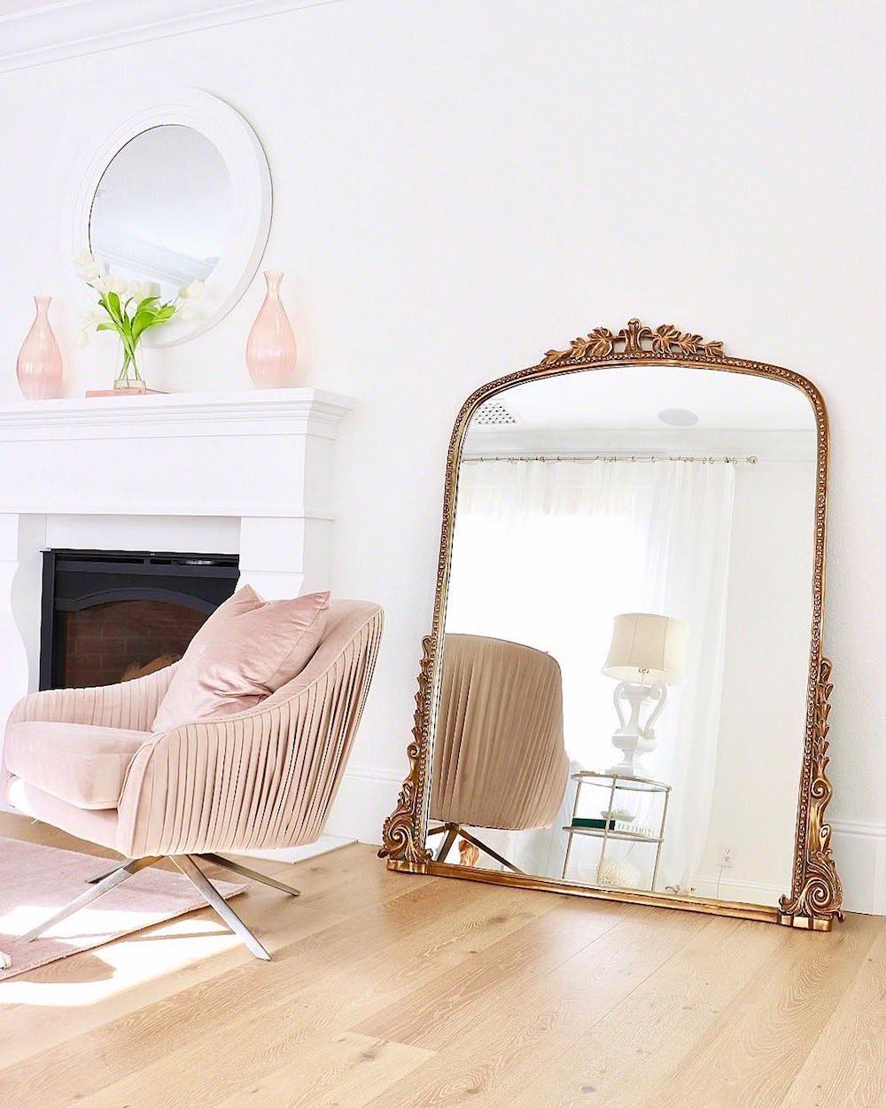 Gold 7-foot Gleaming Primrose Mirror with blush velvet chair in living room