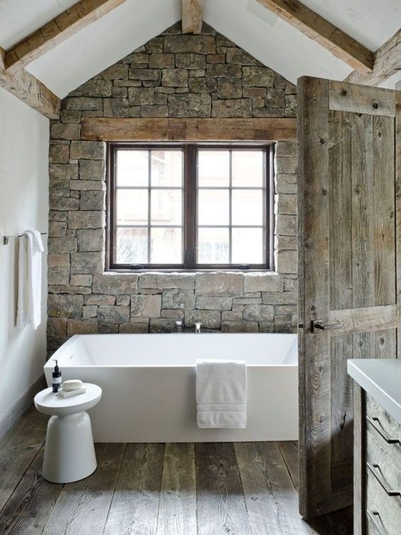 Rustic Stone Wall Bathroom With Wood Panel Flooring And Wooden Door