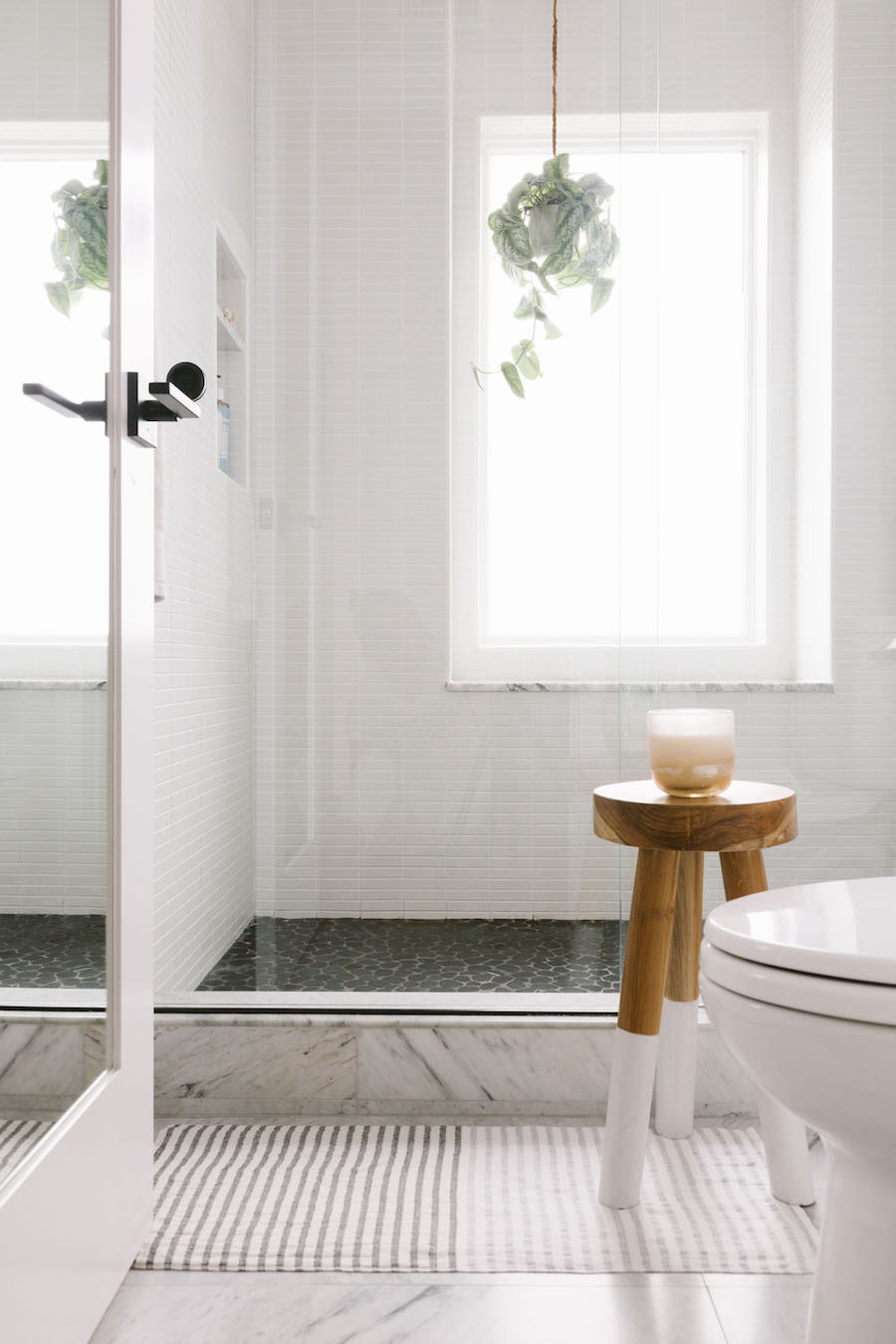 White Shower With Hanging Plant And Grey Floor Tile Bathroom