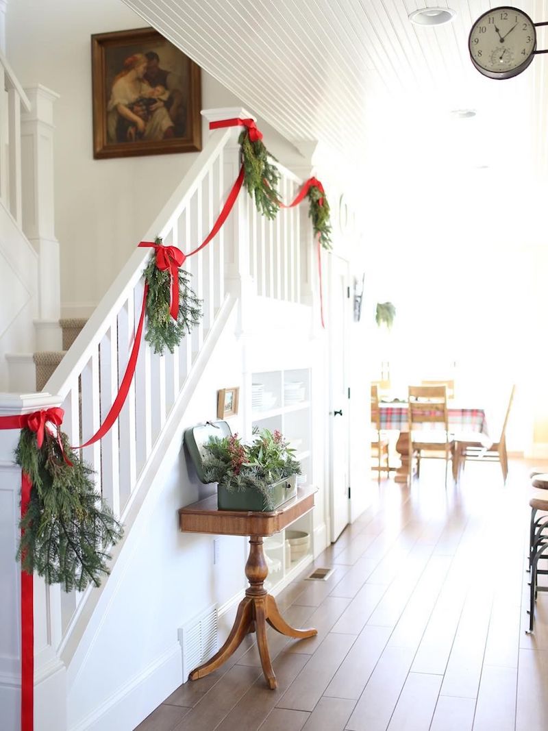 Green Wreaths with Simple Red Ribbon Staircase Decor via @thefarmchicks