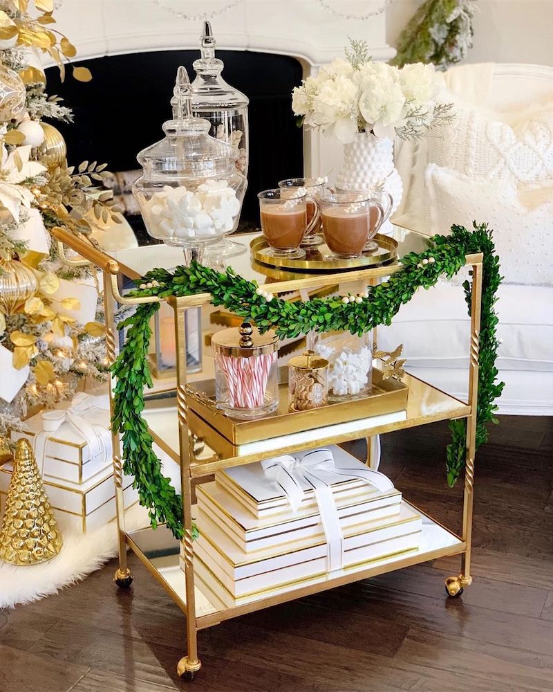 https://curatedinterior.com/wp-content/uploads/2018/12/Hot-Chocolate-on-a-Gold-Bar-Cart-with-Christmas-Garland-via-@thedecordiet.jpg