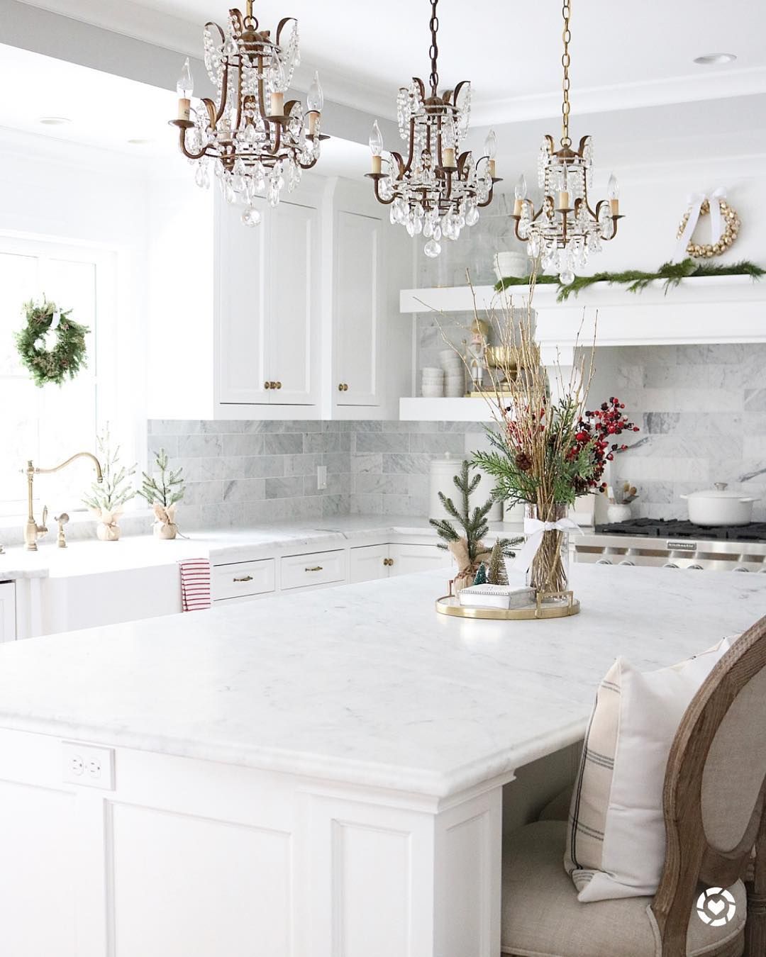 3 crystal chandelier pendants above white kitchen island