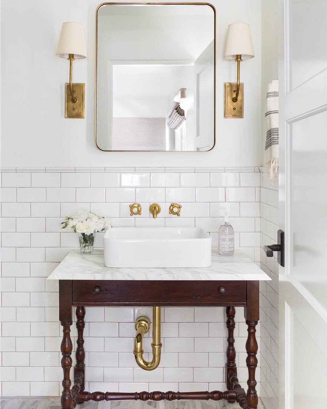 Bathroom with subway tile, vessel sink and brass hardware