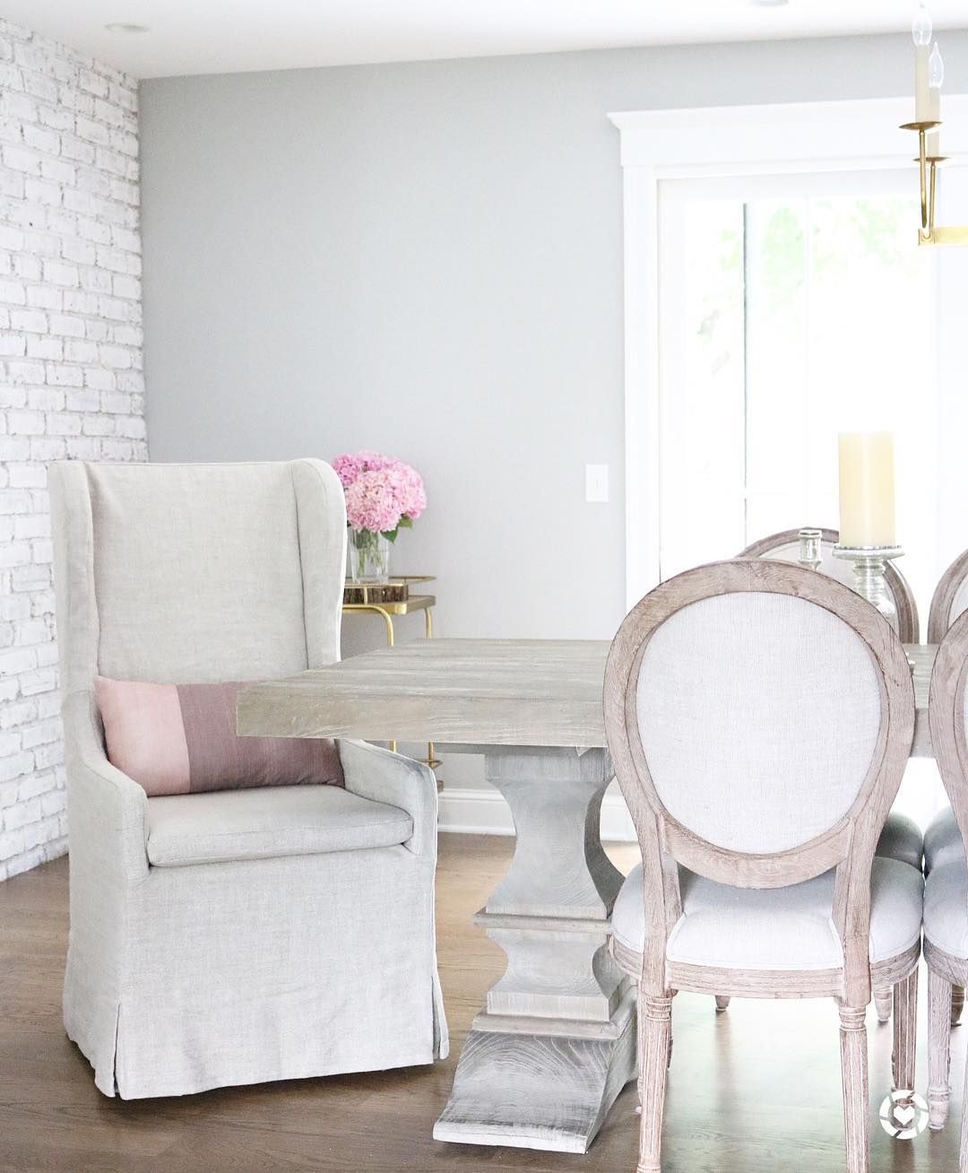 Feminine farmhouse dining room with french dining chairs and slipcover chair