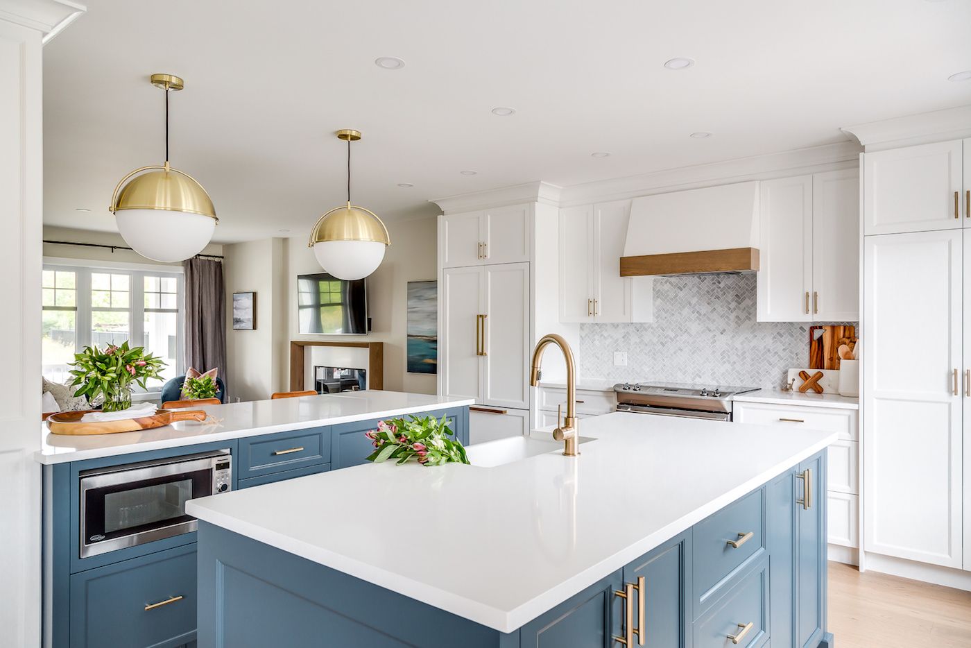 Kitchen with turquoise cabinets and brass pendant lights