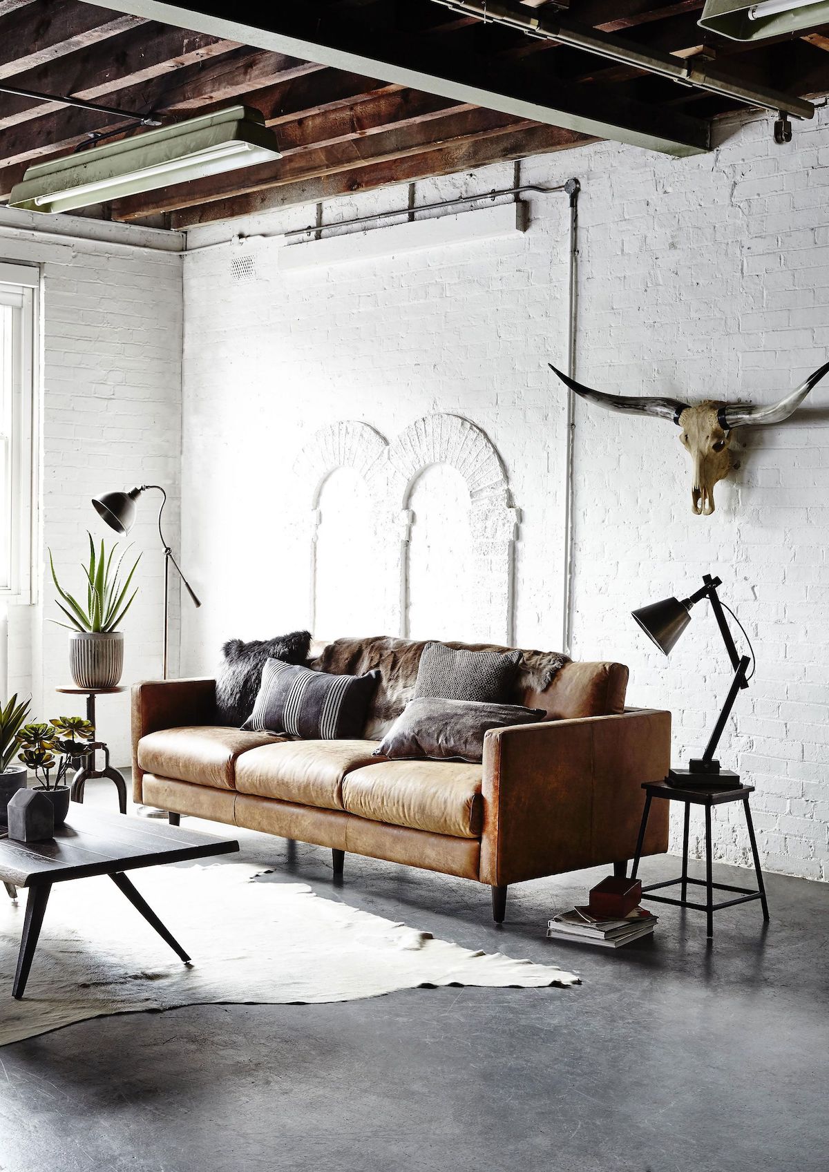 Industrial throw pillows on a brown leather couch in the living room