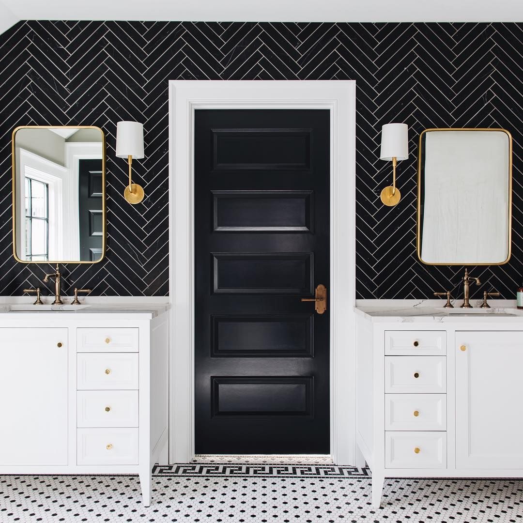 Bathroom with Double Vanity and Black Herringbone Tiles on wall and black door @stofferphotographyinteriors