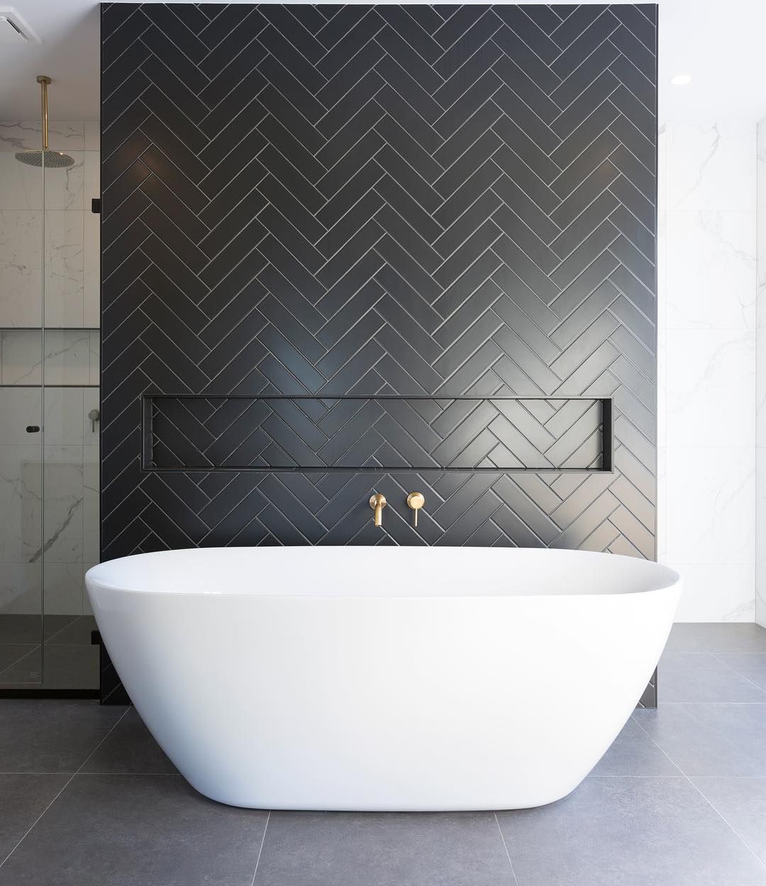 Bathrooms with Black Herringbone Tiles and white freestanding bathtub @turboconstructionau