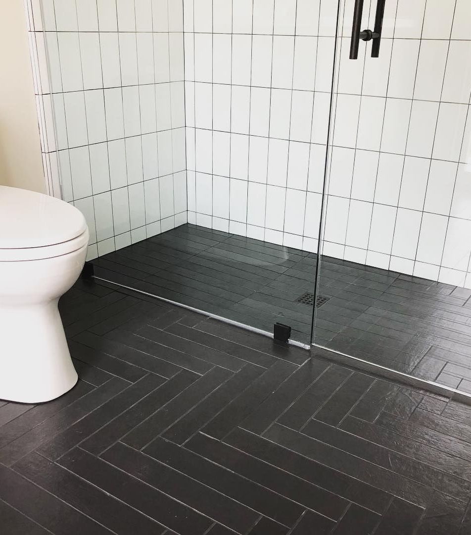 Bathrooms with black herringbone floor tiles via @kishagiannidesigns