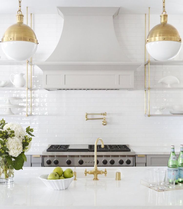 Brass Pendant Lights above white kitchen island via @sharontaftianinteriors