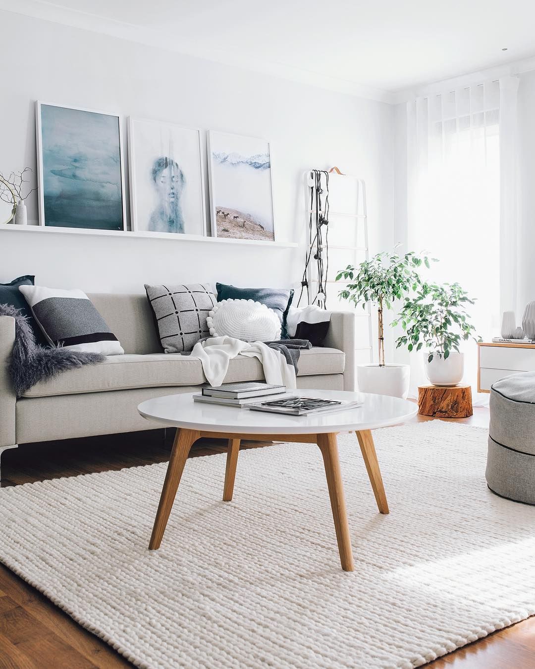 Off-white woven wool rug with a light gray sofa and a round white coffee table with wood legs