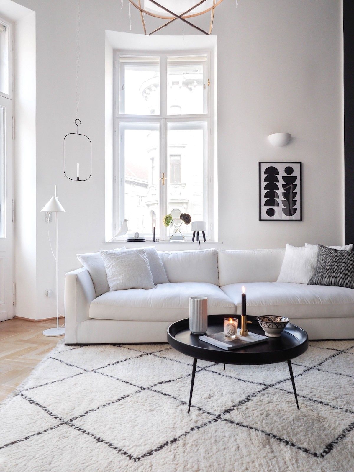 Scandinavian Rug under white sofa and black coffee table via traumzuhause