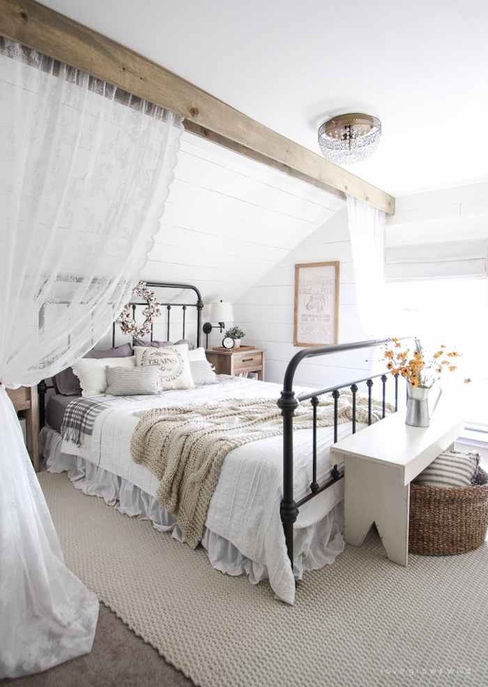 Farmhouse Bed with metal frame in room with wood ceiling beam via lovegrowswild