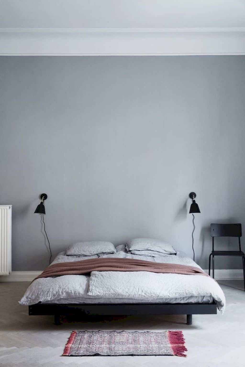 Black Scandinavian wall sconces in bedroom