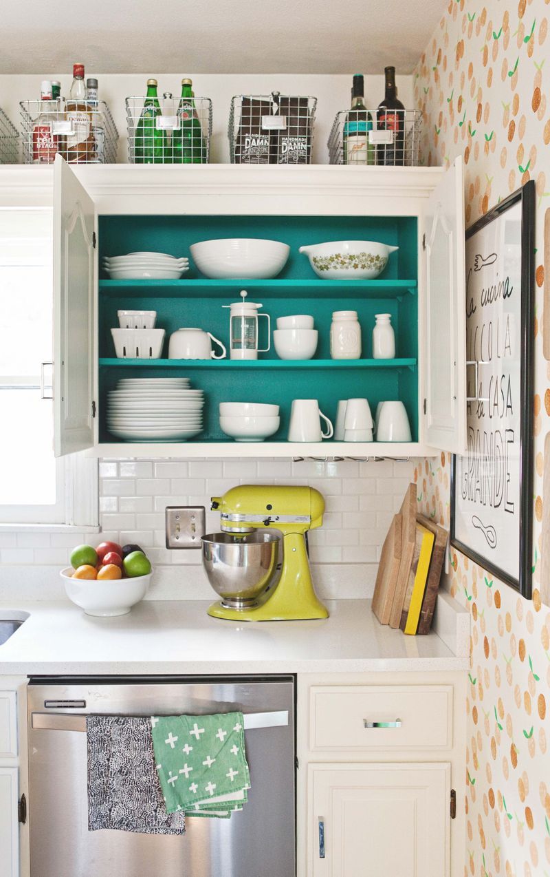 Colorful Kitchen Cabinet Organization with Wire Baskets on top via A Beautiful Mess