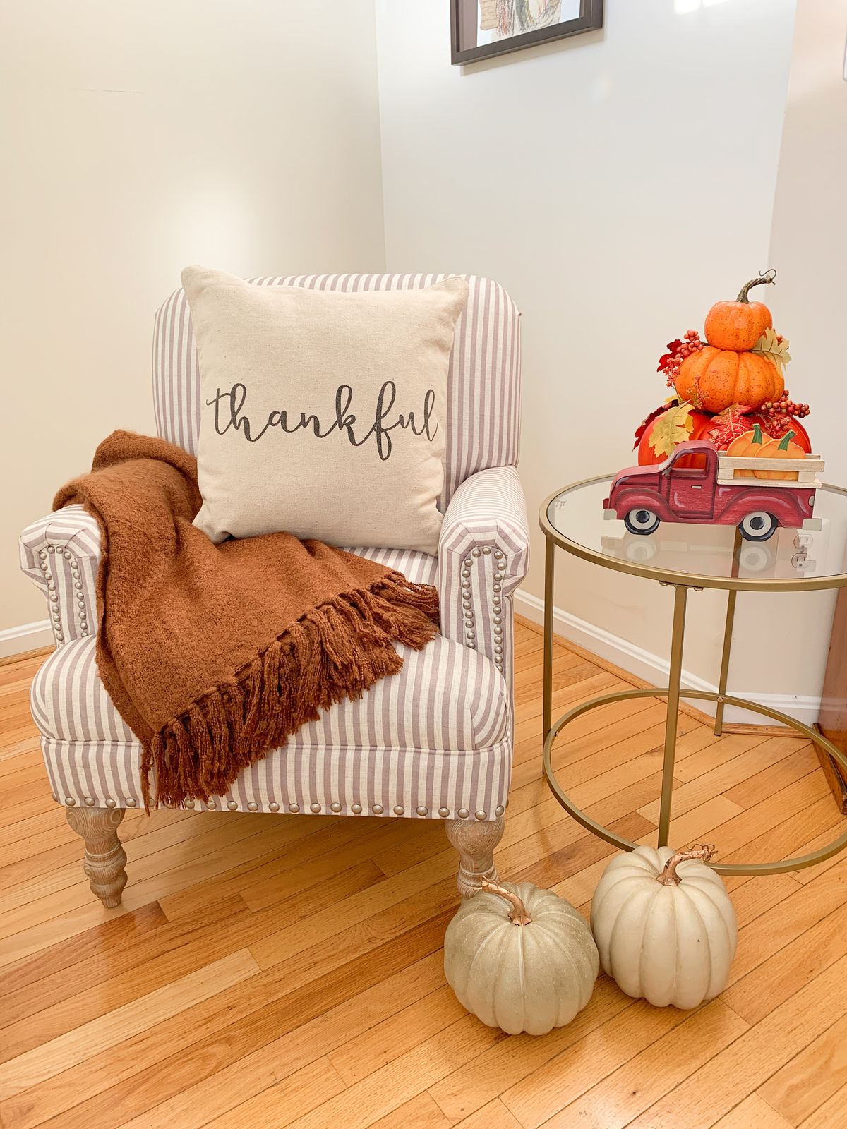 Cozy Fall Accent Chair Decor - Beige striped chair from Walmart, rust orange blanket, pumpkin decor and fall harvest truck decor