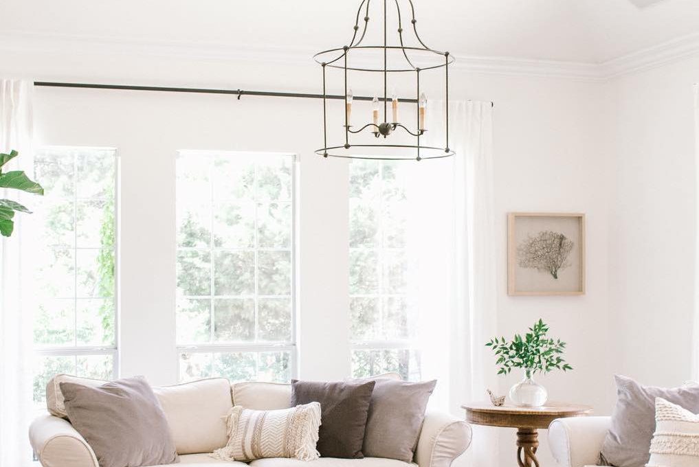 Iron chandelier in Farmhouse living room with slipcovered sofa and wood coffee table via @shopfarmhouseliving