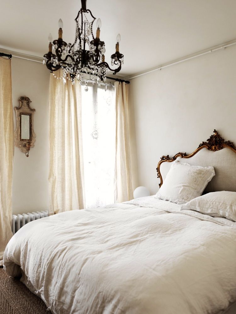 Parisian bedroom with French headboard and chandelier via Marianne Tiegen