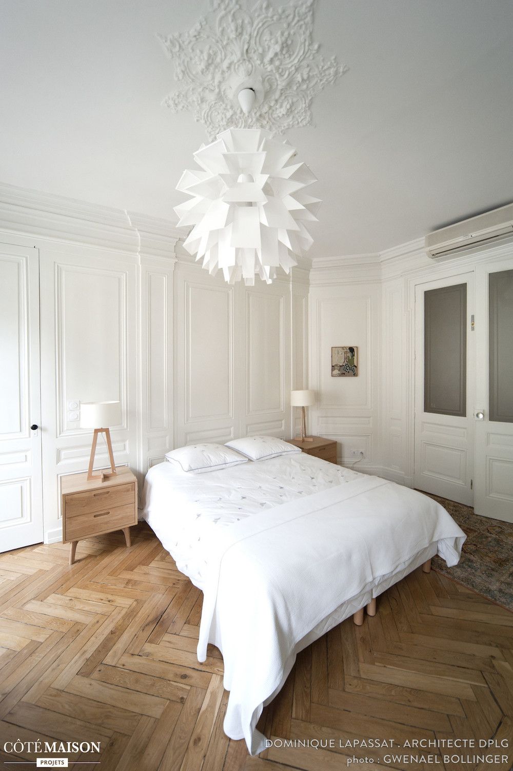 Parisian bedroom with Modern light fixture and herringbone wood floors via Dominique Lapassat