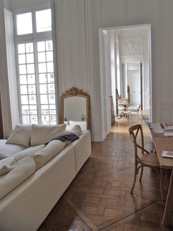 Parisian living room decor with beige sofa and leaning wall mirror