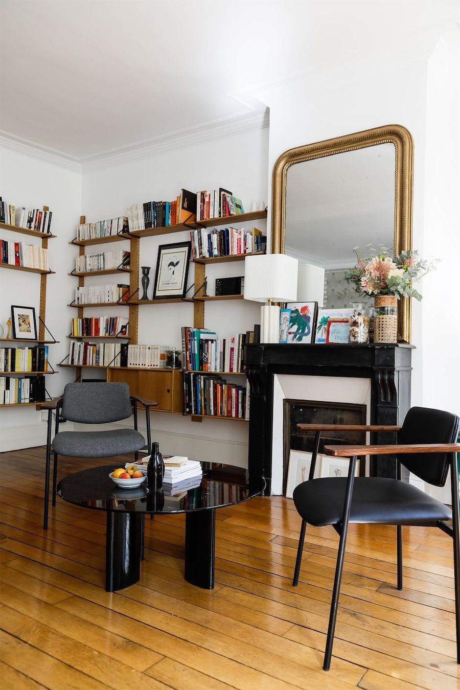 Parisian living room with black accent chairs, black accent table, and black fireplace