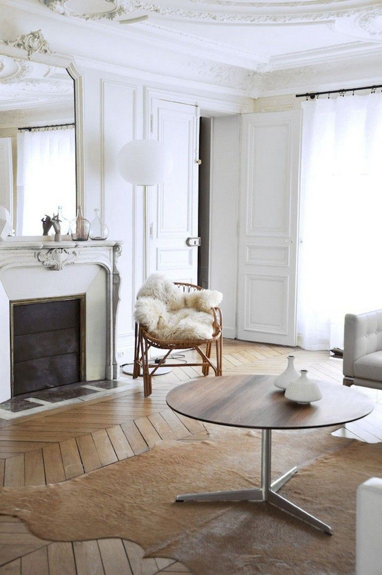 Parisian living room with cowhide rug, rattan chair and brown round coffee table