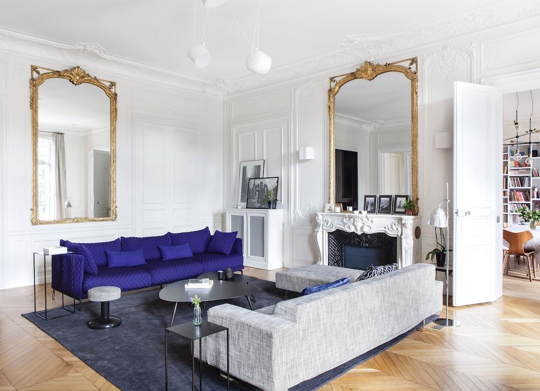 Parisian living room with Simple gray sofa and Ornate gold wall mirrors via nuevo estilo Camille Hermand