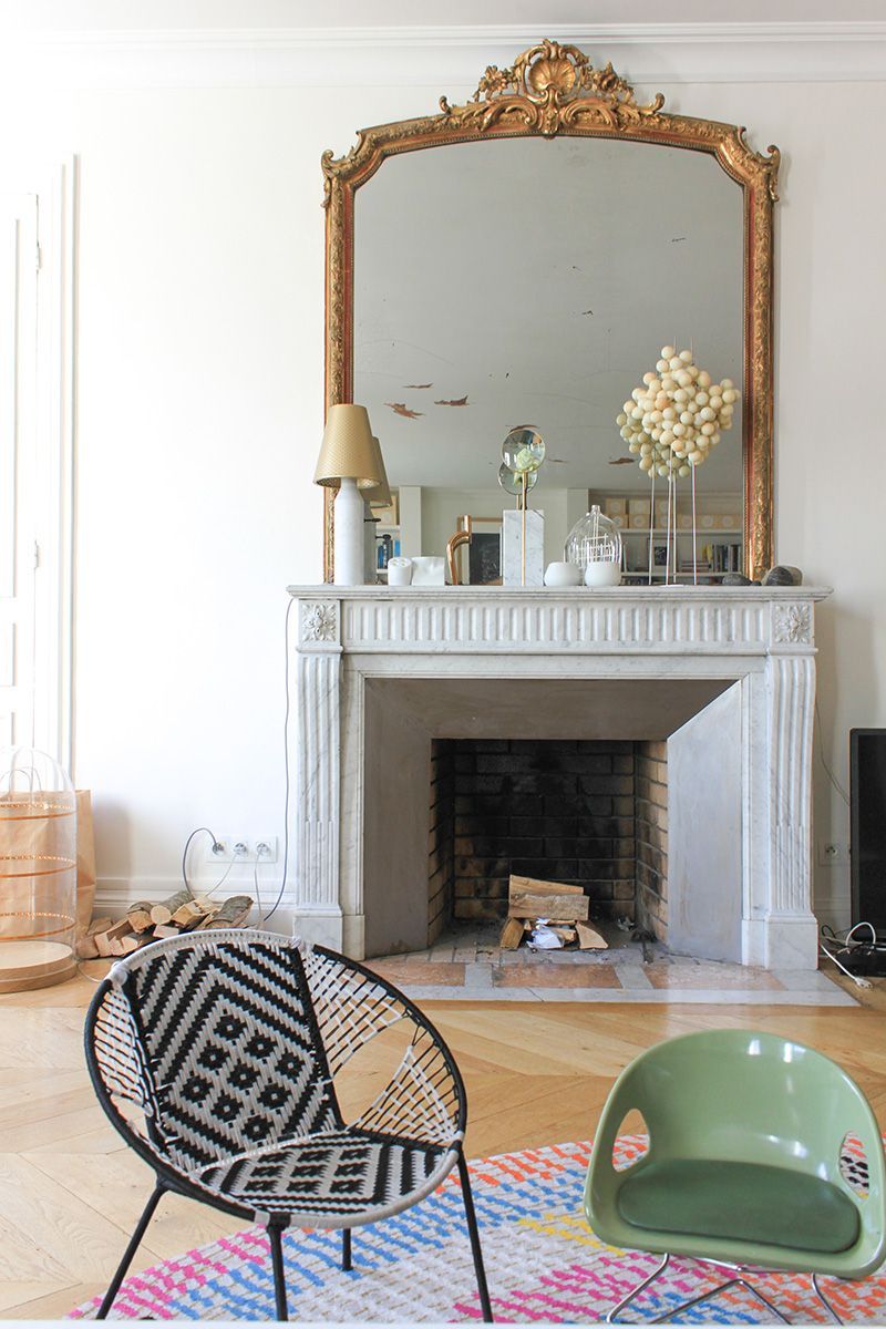 Parisian living room with modern accent chairs and marble fireplace via FrenchyFancy