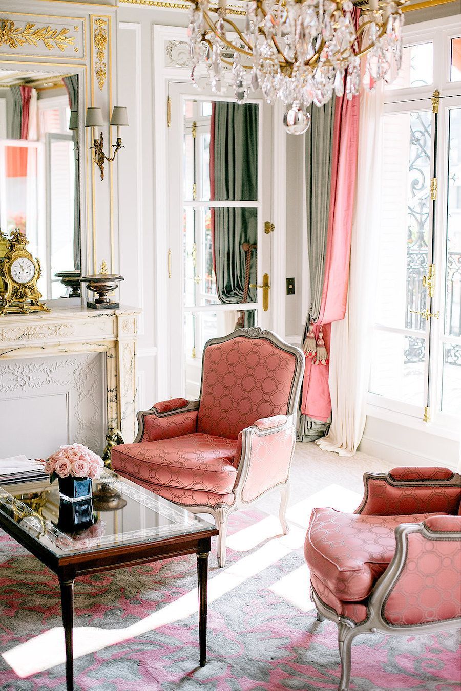 Parisian living room with pink Louis fauteuil accent chairs via journeyintolavillelumiere la plaza athenee