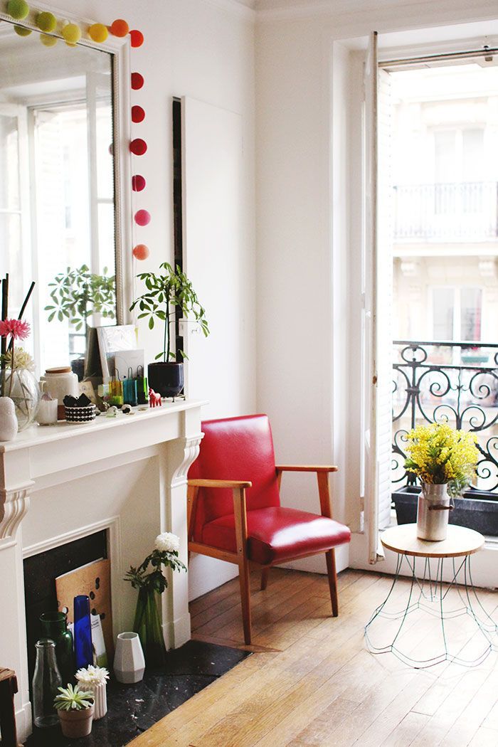 Parisian living room with red leather accent chair via designsponge