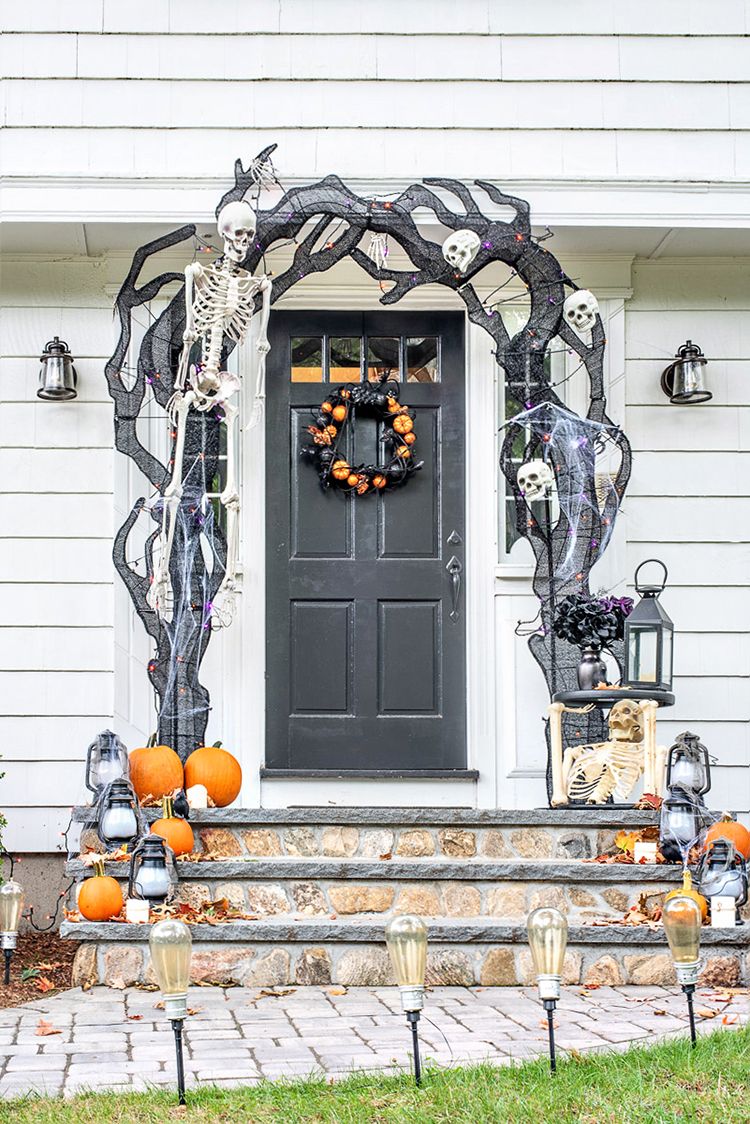 Black trees and cobwebs framing the front door on this Halloween Front Porch Decor ideas via Jenna Kate at Home