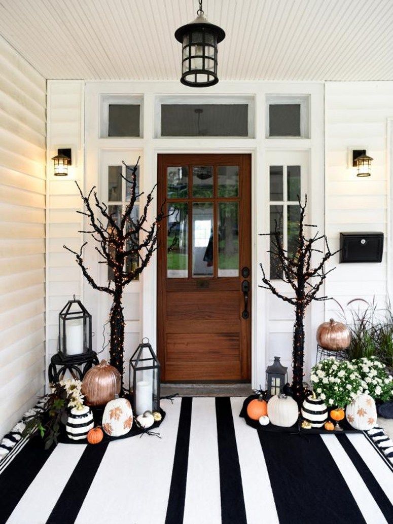 Halloween front porch decor with black and white striped rug via HGTV