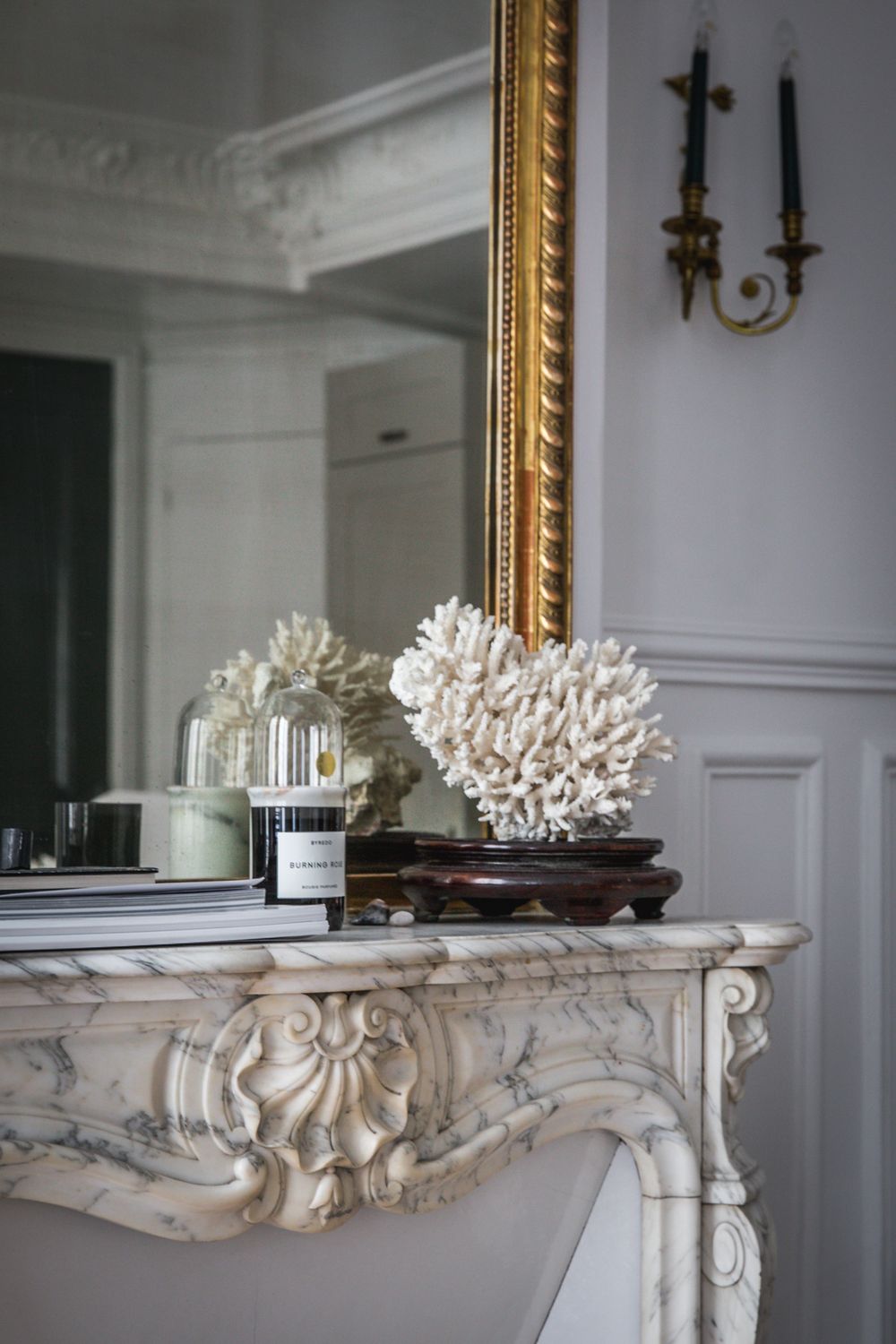 Parisian Fireplace with Byredo candle and coral sculpture via AptLafayetteParis