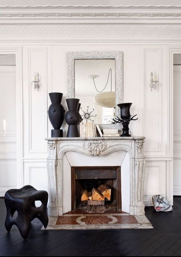 Parisian Black and white Fireplace with Books and black vases via Elle