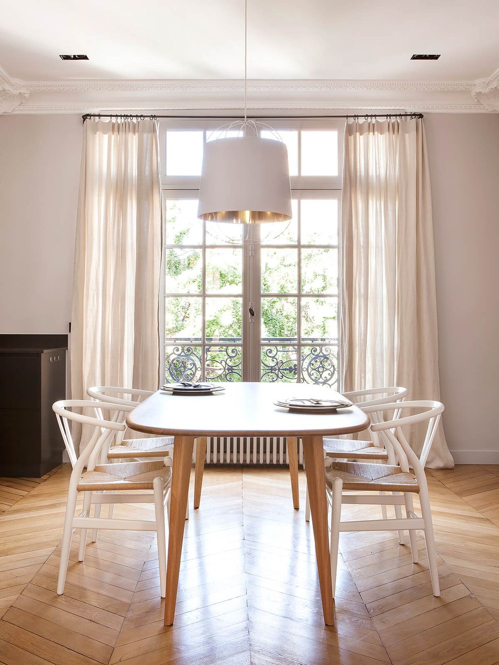 Parisian dining room decor with White wishbone chairs via Camille Hermand