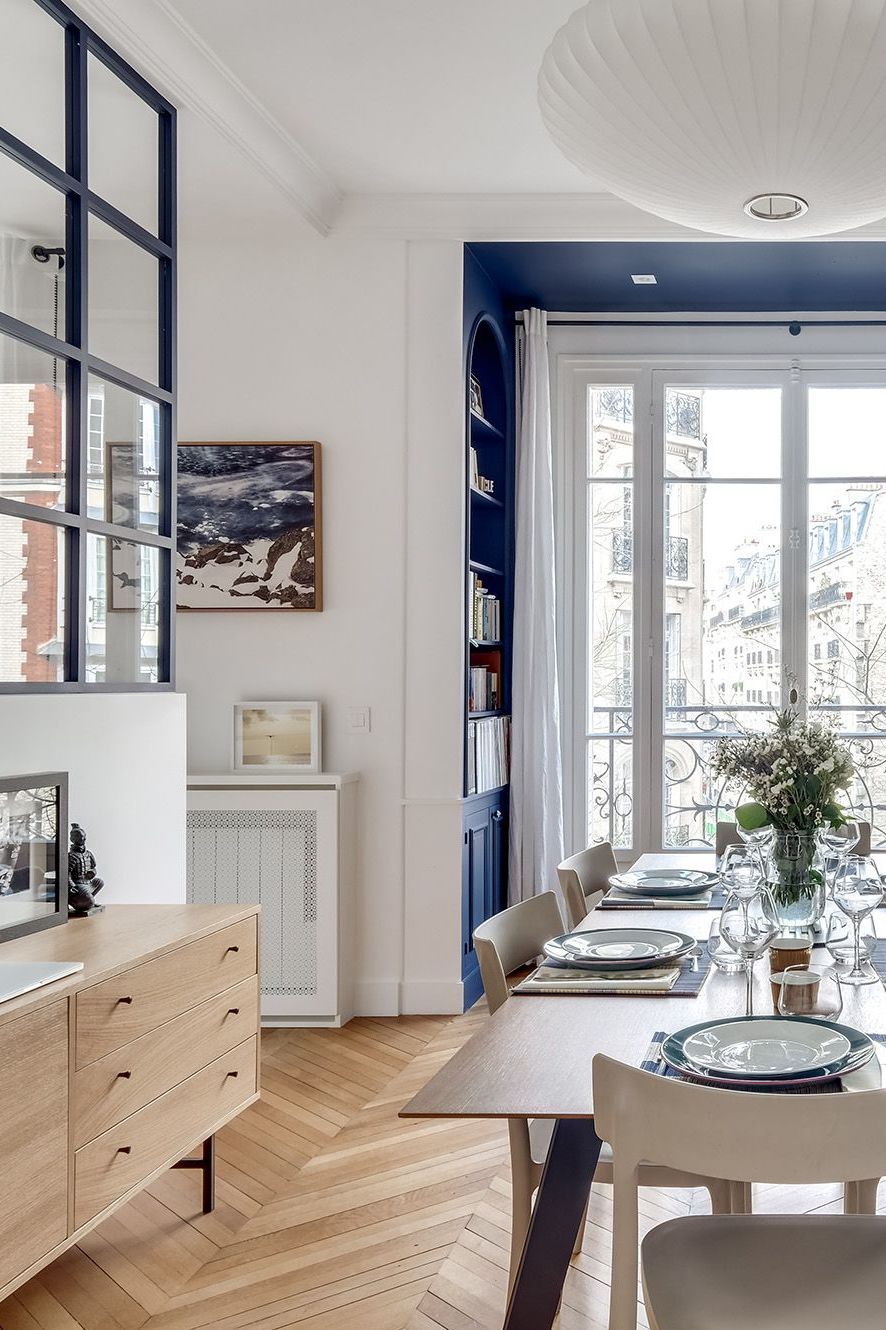 Parisian dining room design with Blue bookshelf and neutral wood buffet via Elodie Cottin CoteMaison