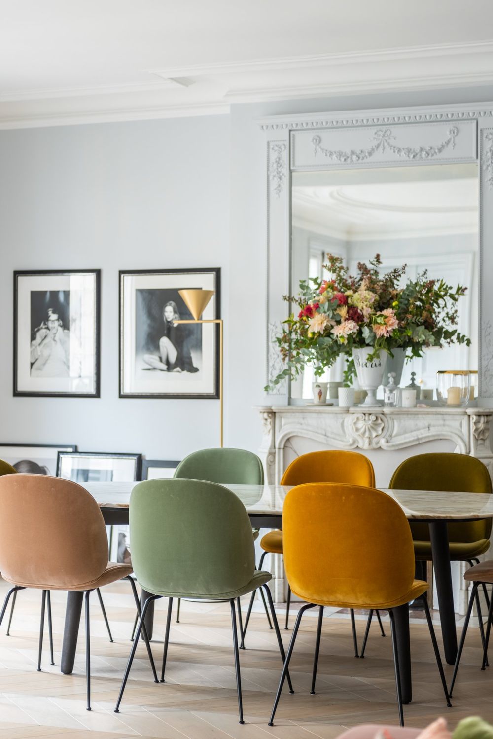 Parisian dining room with yellow, green, and pink dining chairs via The Socialite Family Florence Elkouby