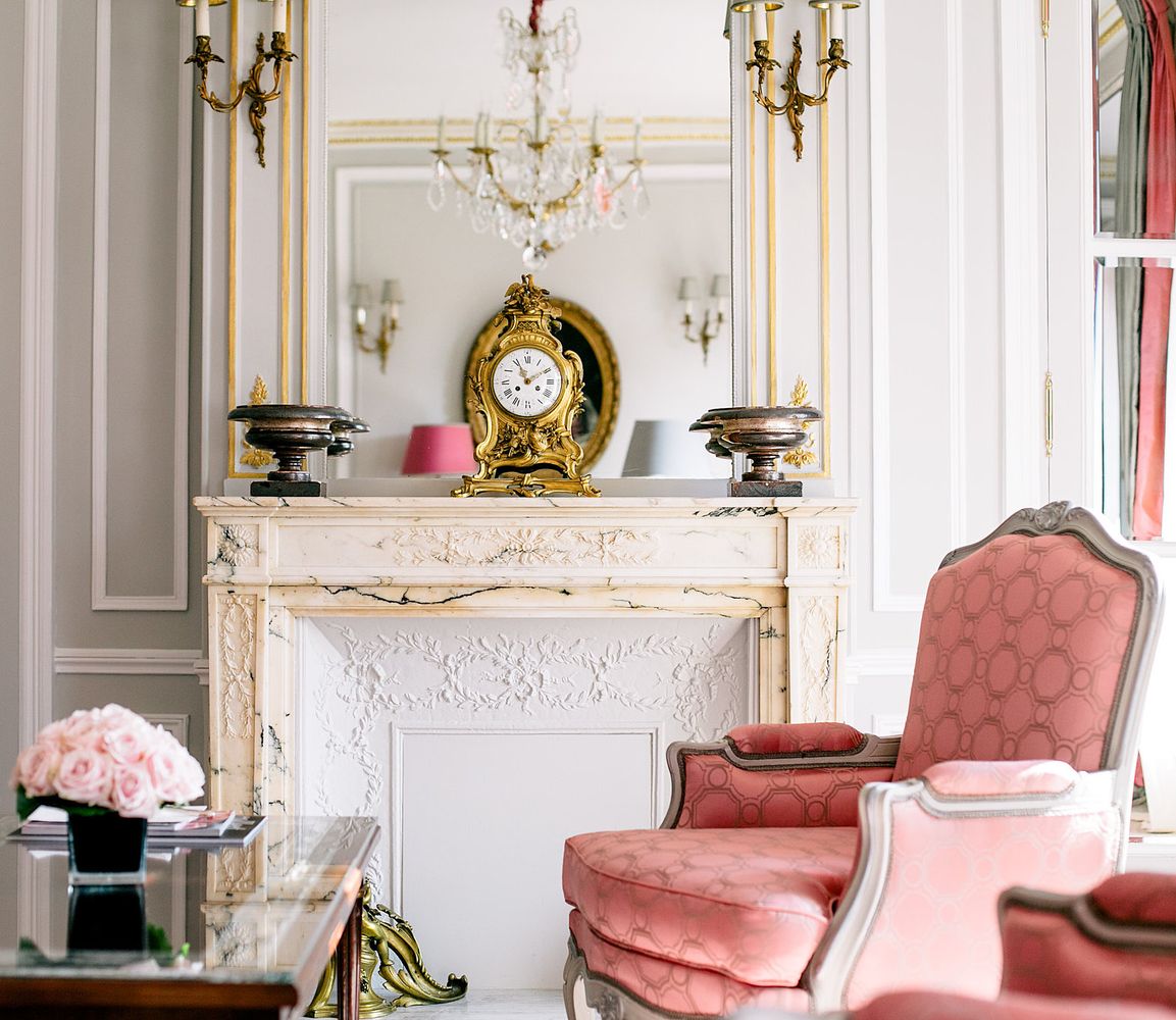 Parisian fireplace with antique clock at la plaza athenée hotel via journeyintolavillelumiere