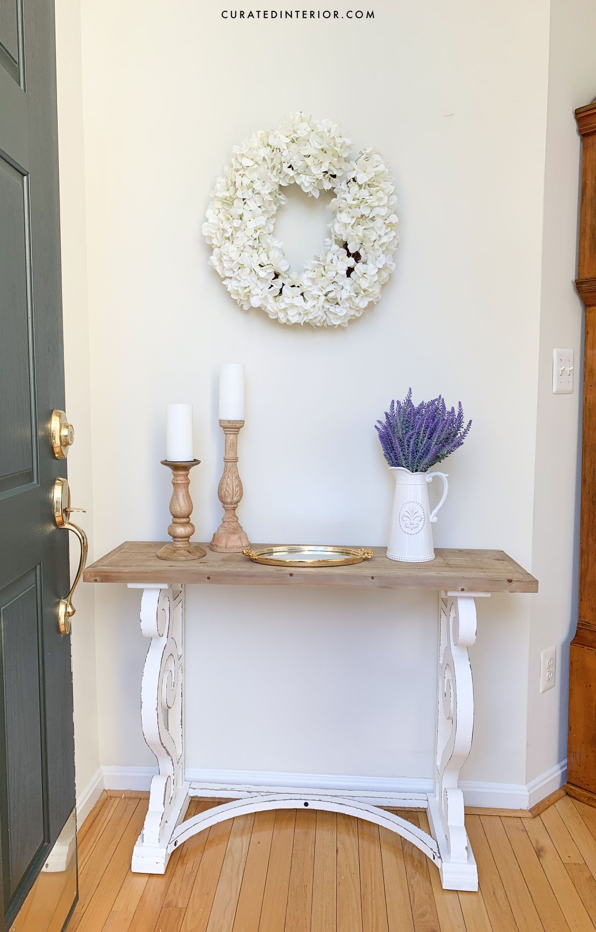 French Country Entryway with Floral Wreath, Wood Console Table and Lavender in a white Farmhouse Pitcher