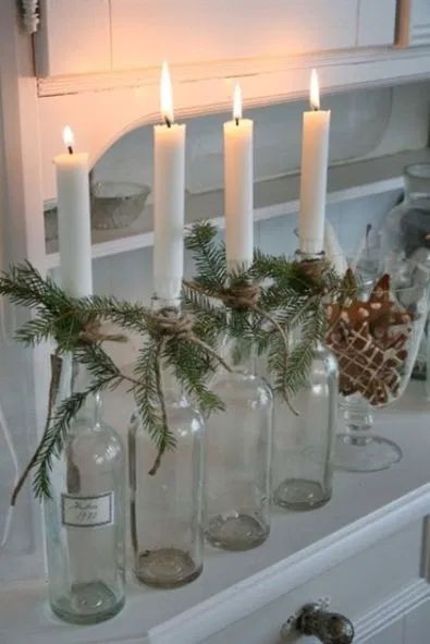 DIY Scandinavian Christmas Decorations Glass bottle candle holders with evergreen branches