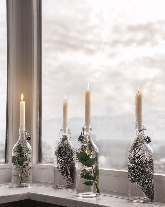 DIY Scandinavian Christmas Decorations Water filled glass bottle candle holders with small evergreen branches inside