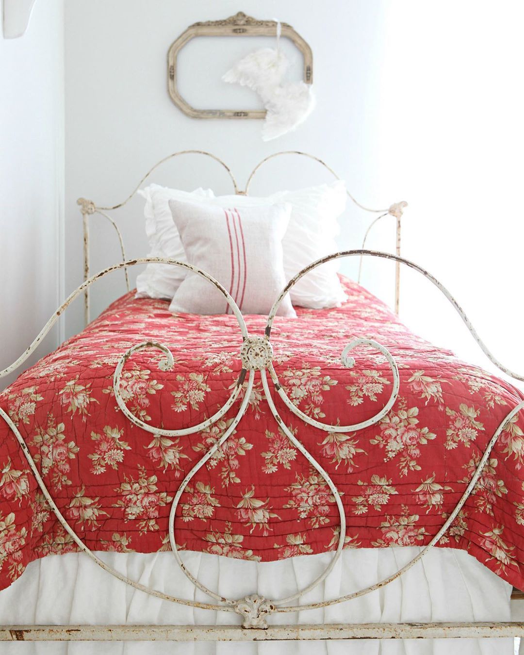 French country bedroom with Antique iron bed and red floral bedspread via @frenchlarkspur