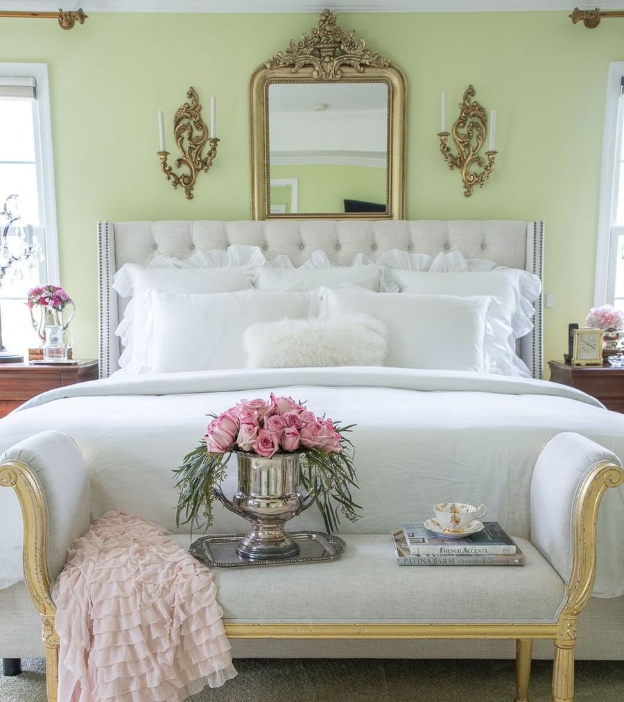 Gold Mirror above Beige Tufted Headboard in French Country Bedroom with bench via @designthusiasm